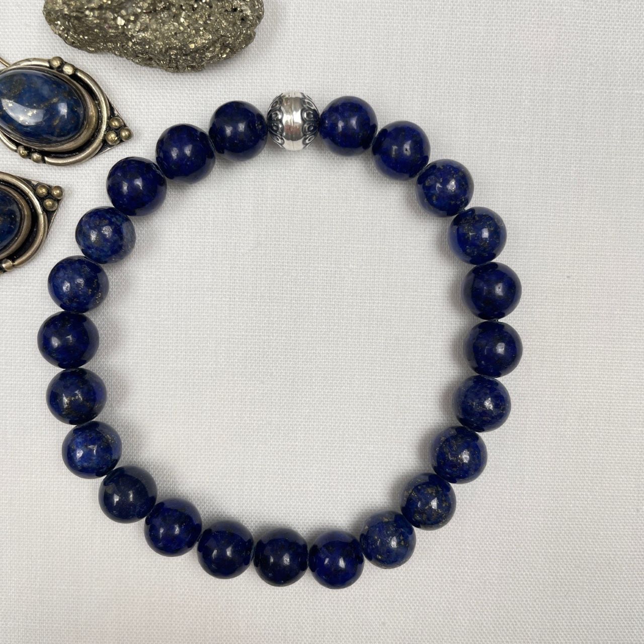 Deze stoere armband is geregen van lapis lazuli kralen van AA kwaliteit en een geoxideerde sterling zilveren kraal. De kralen zijn diep donkerblauw, maar hebben wel verschillende tinten; dit maakt de armband ook levendig. De kralen zijn ongeveer 8 mm in doorsnede. De zilveren kraal is glad met aan de zijkanten een bladmotief.