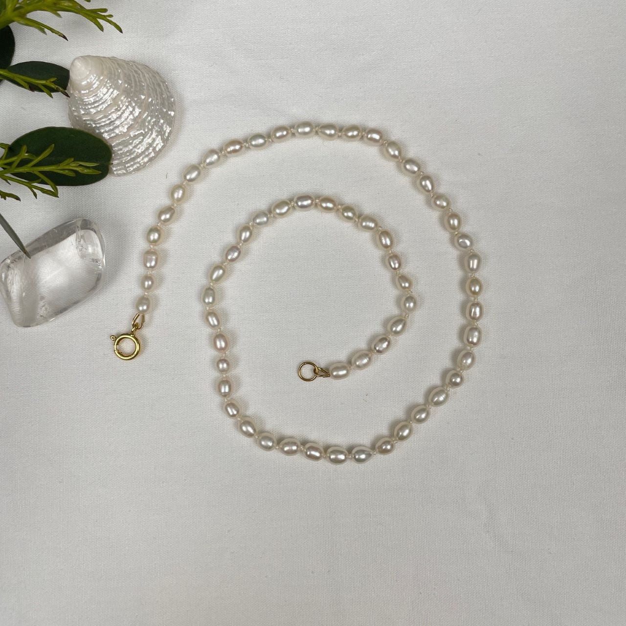 De zoetwaterpareltjes zijn geknoopt op een dubbele zijden draad. De parels hebben een rijstkorrelvorm en zijn 5 tot 6 mm lang. De ketting sluit met een decoratief gold filled veerslotje.