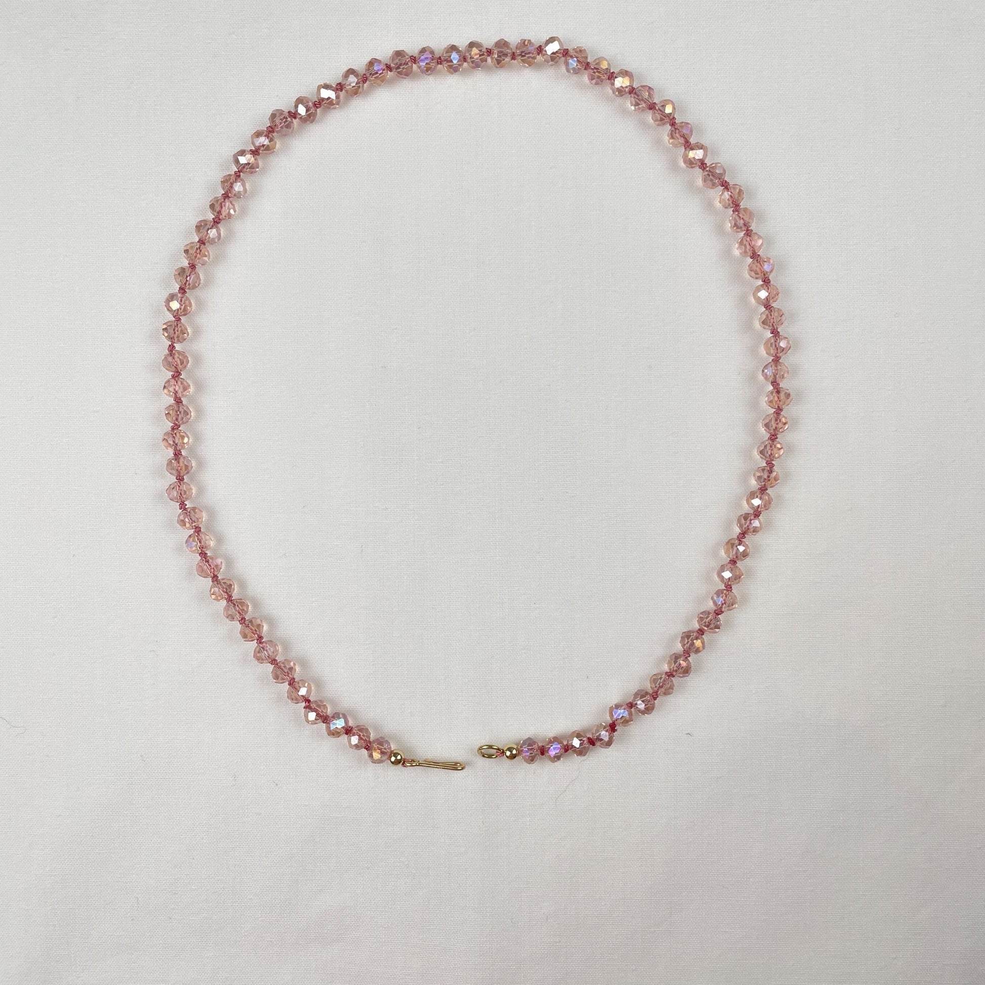 Deze ketting van roze facet kristal rondellen is geknoopt met roze zijde. Door de facetjes schittert de ketting je tegemoet en zie je allerlei kleuren zoals goud, lila en blauw. De ketting eindigt met een een paar gold filled kralen en sluit een gold filled haakje.