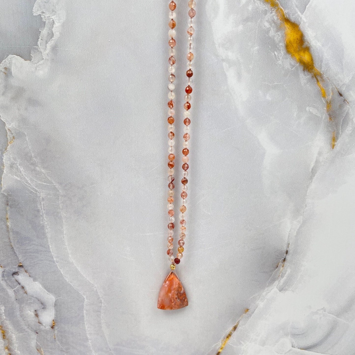 Mala ketting van red healer facetkralen met een hanger van een 14K gold filled kraal en een driehoekige carneool steen. 